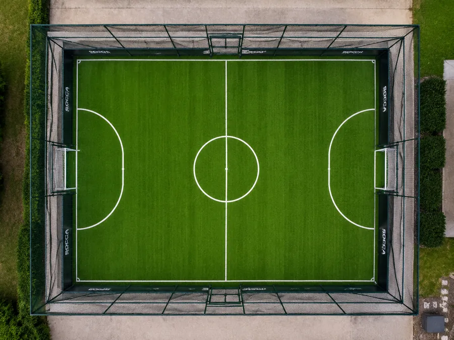 Vue aérienne d'un terrain de foot à 5 en gazon synthétique, entièrement clôturé