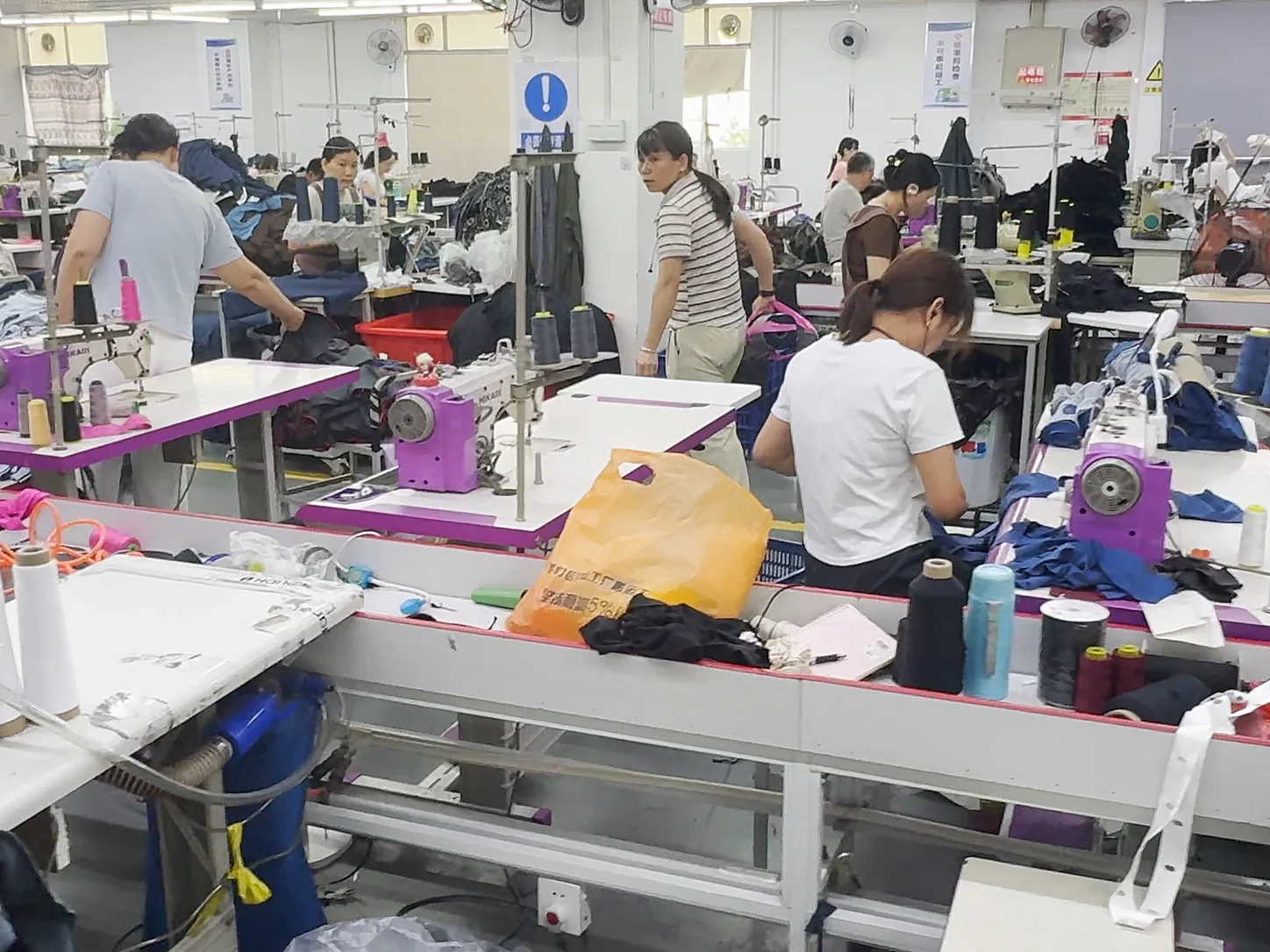 A busy garment workshop in southern China with staff at their sewing machines