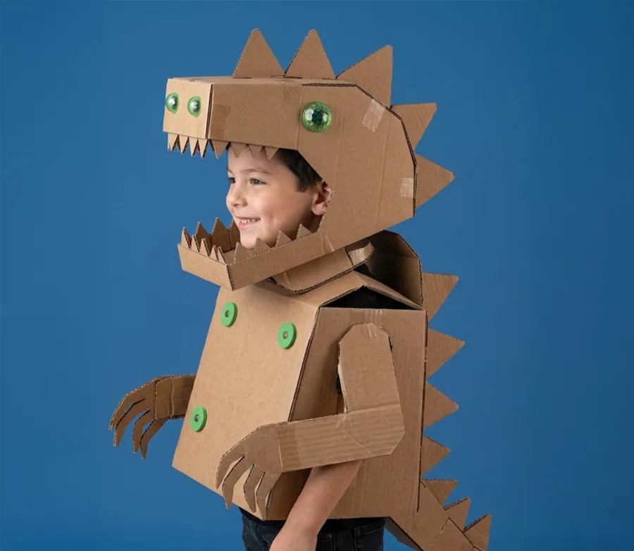 Child wearing a cardboard dinosaur costume toy